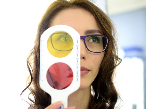 Pretty Young Woman Optometrist Ophthalmologist Optician Performs A Color Blindness test