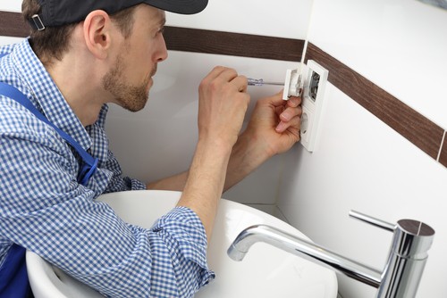 A Electrician Changing A Socket Outlet In Bathroom